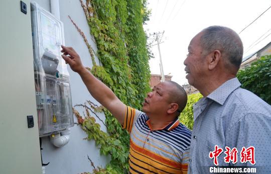 田茶村光伏电站管理人员和村民查看发电情况。　黄水林 摄