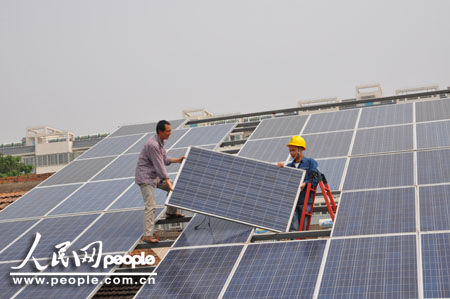 杨凌供电分局员工正在和村民夏保国检修太阳能光伏玻璃板