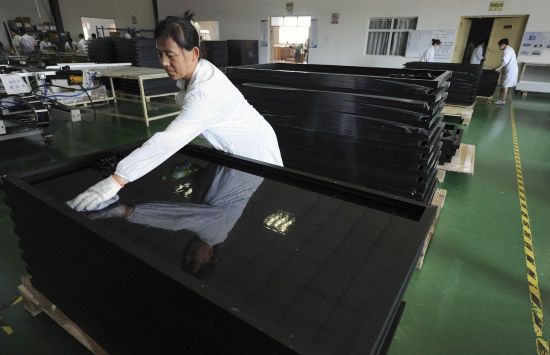 中国合肥一工厂的工人擦拭太阳能电板。相对欧洲廉价的劳动力降低了电板的生产成本，成为欧盟展开反倾销调查的借口之一。
