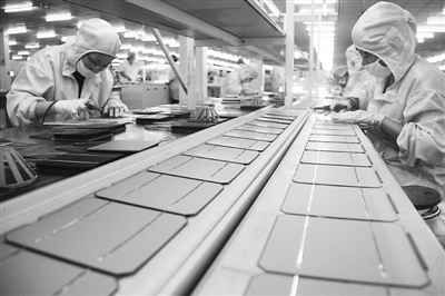 8月7日，江苏南通一家光伏新能源企业职工在生产太阳能电池组件